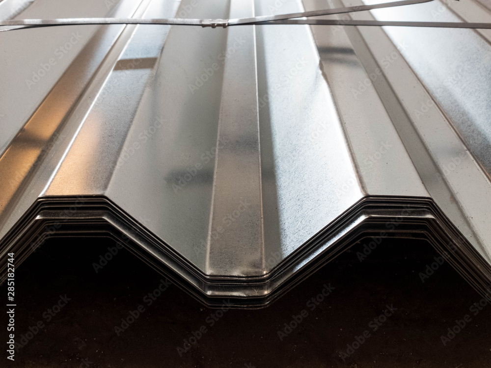 Fototapeta premium Stacked stainless galvanized profiled sheet. Silver colored construction material