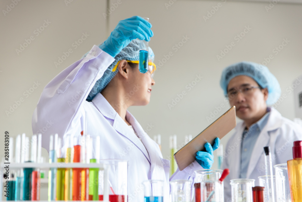Asian woman and men chemists working in the lab and test tubes for scientific research. Asian woman and men chemists working in the lab and test tubes for scientific research.