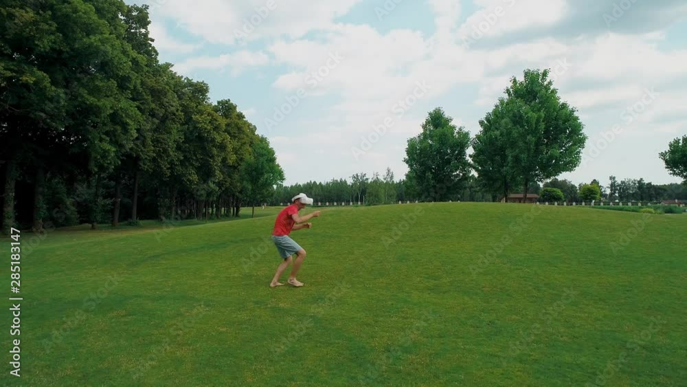 A man using a VR headset and playing a virtual game in the park. Young guy in helmet experiencing augmented reality on the background of nature. A human on the right in the frame. 4K drone footage. A man using a VR headset and playing a virtual game in the park. Young guy in helmet experiencing augmented reality on the background of nature. A human on the right in the frame. 4K drone footage.
