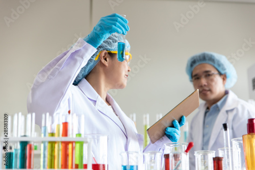 Asian woman and men chemists working in the lab and test tubes for scientific research.