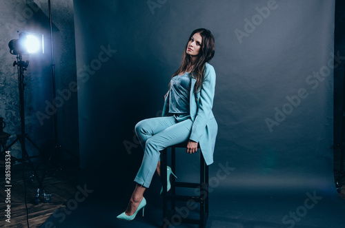 Young woman in blue suit on grey background