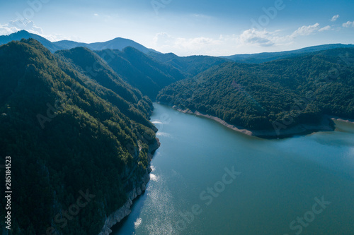 Aerial top view on a Fagaras mountains surrounding Vidraru dam with a reservoir lake