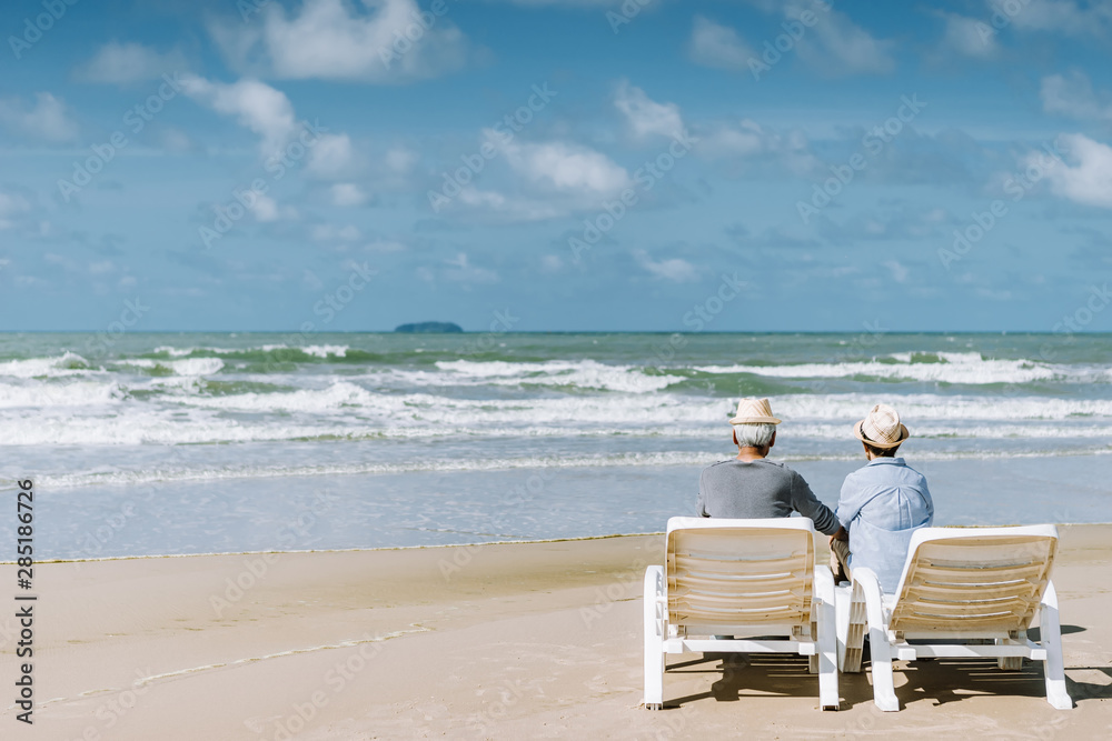 Asian senior couple or elderly people walking and siting at the beach on their weekend vacation holiday. Retirement vaction concept. Asian senior couple or elderly people walking and siting at the beach on their weekend vacation holiday. Retirement vaction concept.