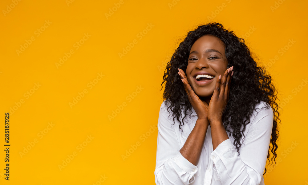 Pretty african american girl laughing and touching her cheeks Pretty african american girl laughing and touching her cheeks
