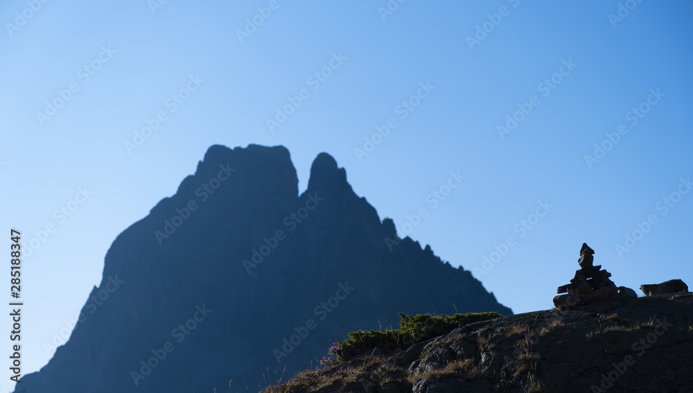 Signaling trails with the Midi d'Ossau peak in the background, Pyrenees natural park, France Signaling trails with the Midi d'Ossau peak in the background, Pyrenees natural park, France