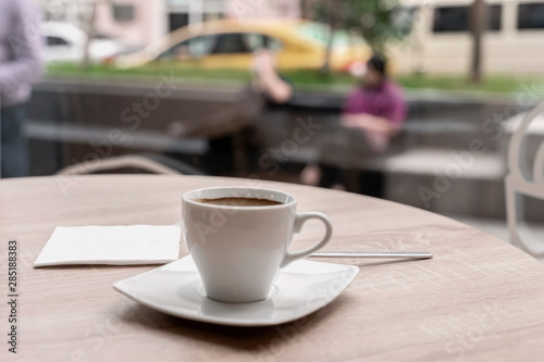 Cup of coffee in a cafe, bar on the background of city life behind glass