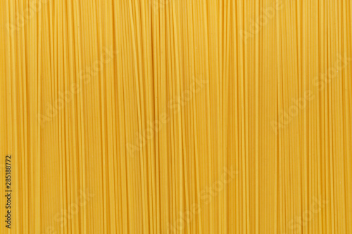 Dry uncooked spaghetti pasta as a background.