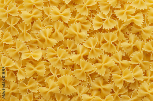 Dry uncooked farfalle pasta as a background.