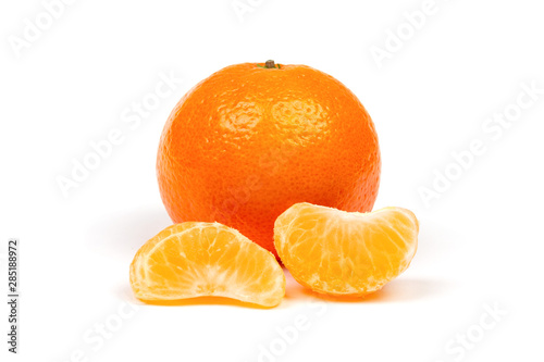 ripe mandarine in peel and peeled tangerine slices close-up isolated on white background