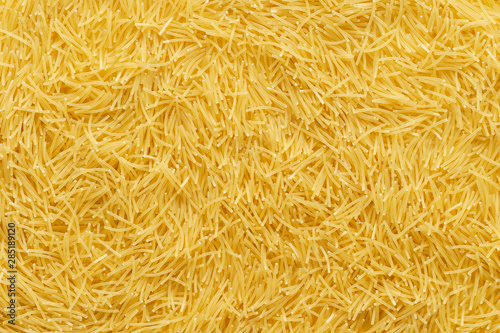Dry uncooked vermicelli pasta as a background.