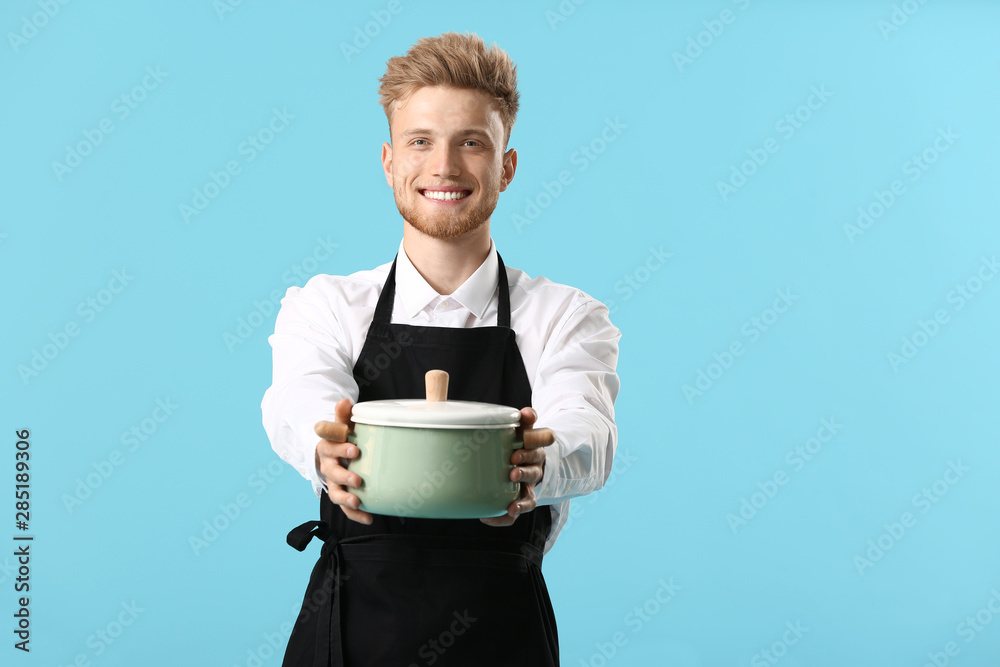 Handsome male chef with soup on color background Handsome male chef with soup on color background