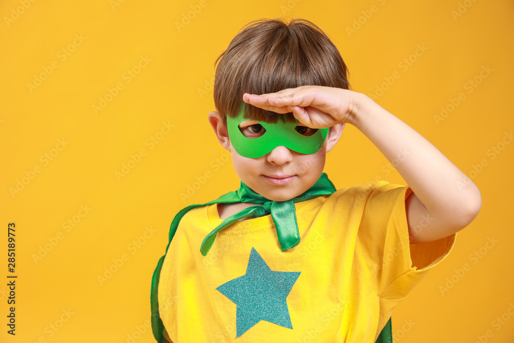 Cute little boy dressed as superhero on color background Cute little boy dressed as superhero on color background