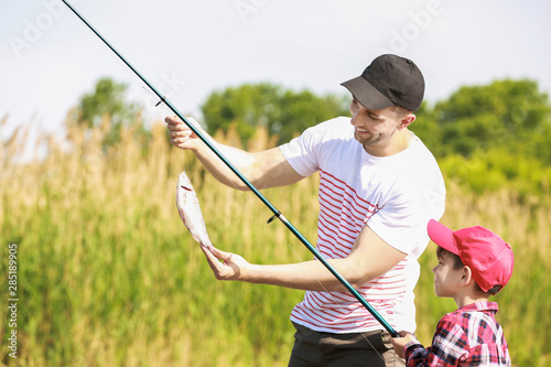 Father and son fishing together on river © Pixel-Shot