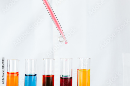 Chemist hands holding test tubes with liquids and doing experiments