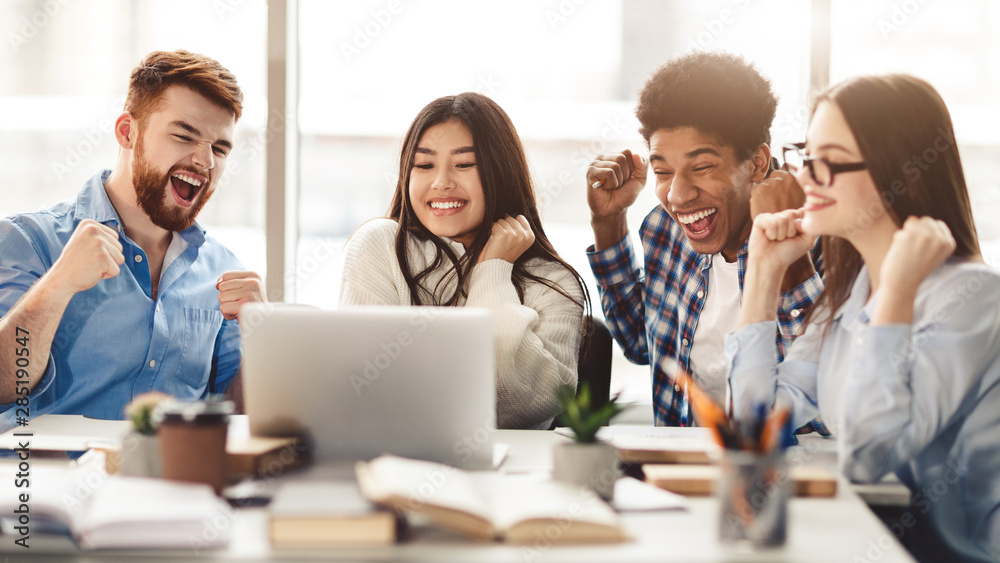 Surprised students getting exam results on laptop Surprised students getting exam results on laptop