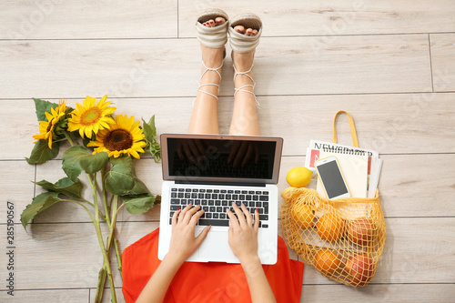 Woman with laptop, sunflowe...