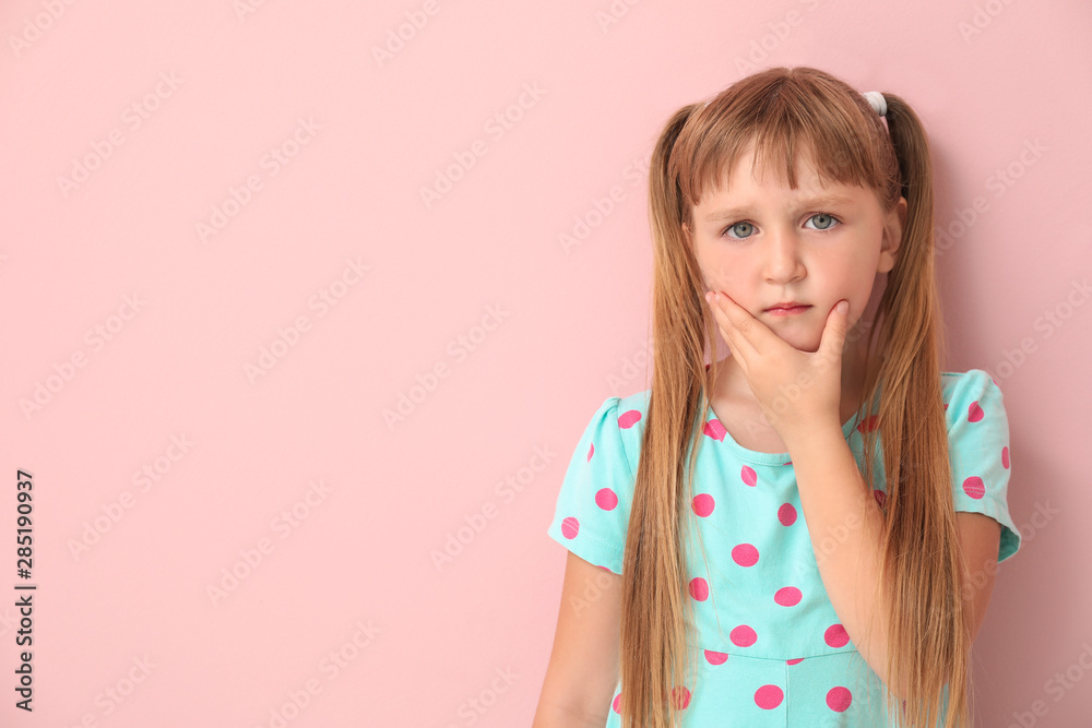 Little girl suffering from toothache on color background Little girl suffering from toothache on color background