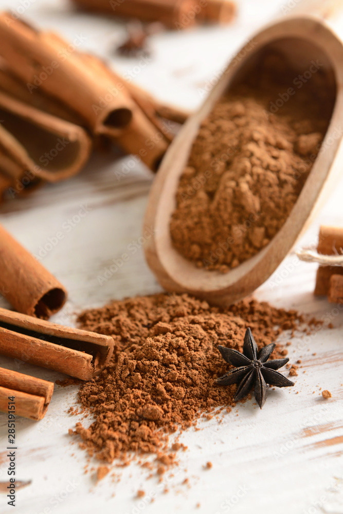 Cinnamon powder and sticks on light wooden background Cinnamon powder and sticks on light wooden background