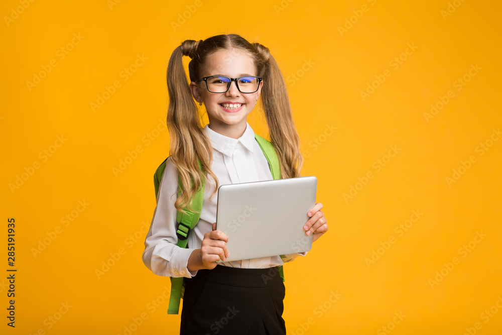 Cheerful Schoolgirl Holding Digital Tablet On Yellow Background Cheerful Schoolgirl Holding Digital Tablet On Yellow Background