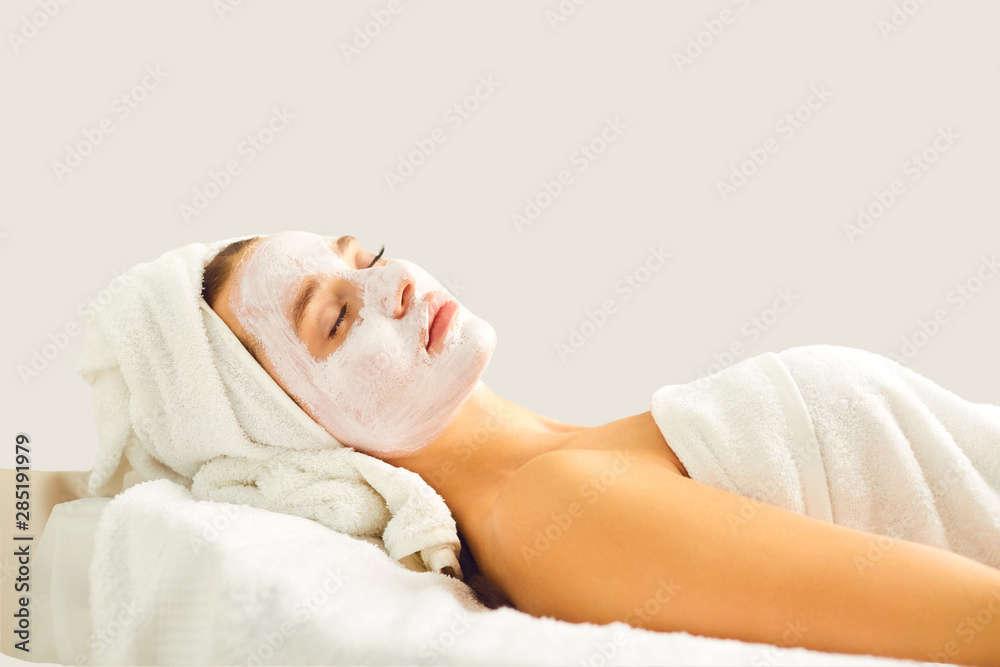 A woman in cosmetologic mask on a gray background. A woman in cosmetologic mask on a gray background.