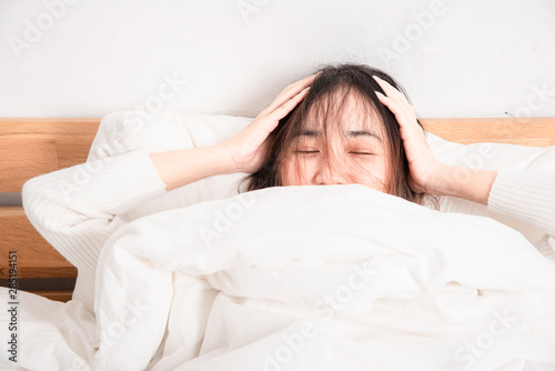 Portrait of beautiful happiness woman lying in white soft comfort bed. Young asian female sleeping in her bed and relaxing in the morning time. Home lifestyle people concept.