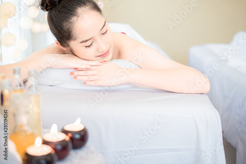 Young healthy asian woman lying relax in spa salon.Traditional Thai oriental aromatherapy and Massage beauty treatments.Recreation vitality wellness wellbeing resort hotel lifestyle leisure.copyspace