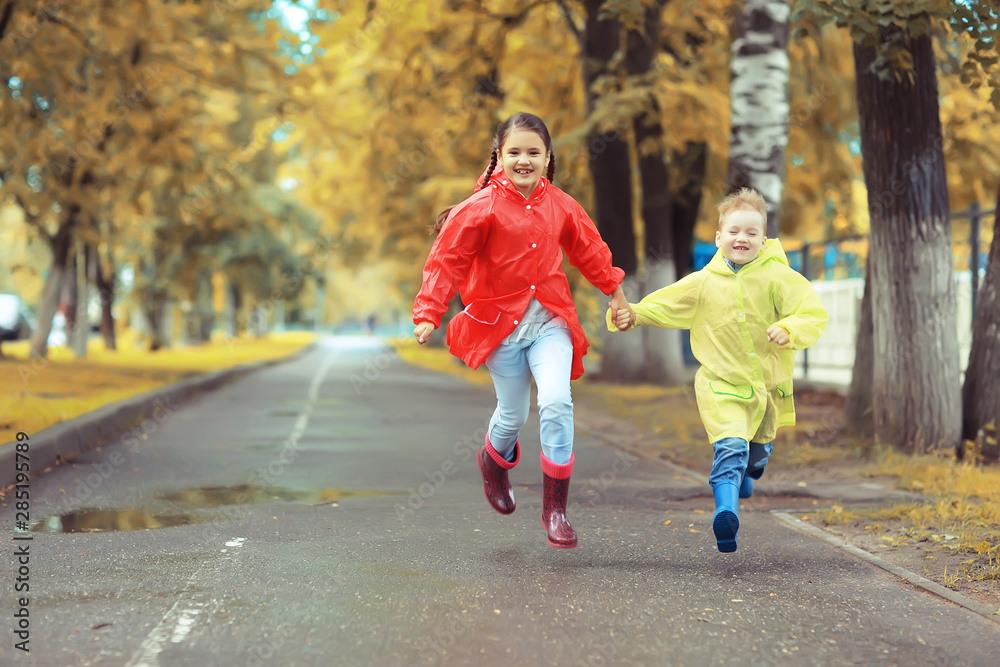 children run in the yellow autumn park rain / fun walk autumn seasonal landscape weather wet children run in the yellow autumn park rain / fun walk autumn seasonal landscape weather wet