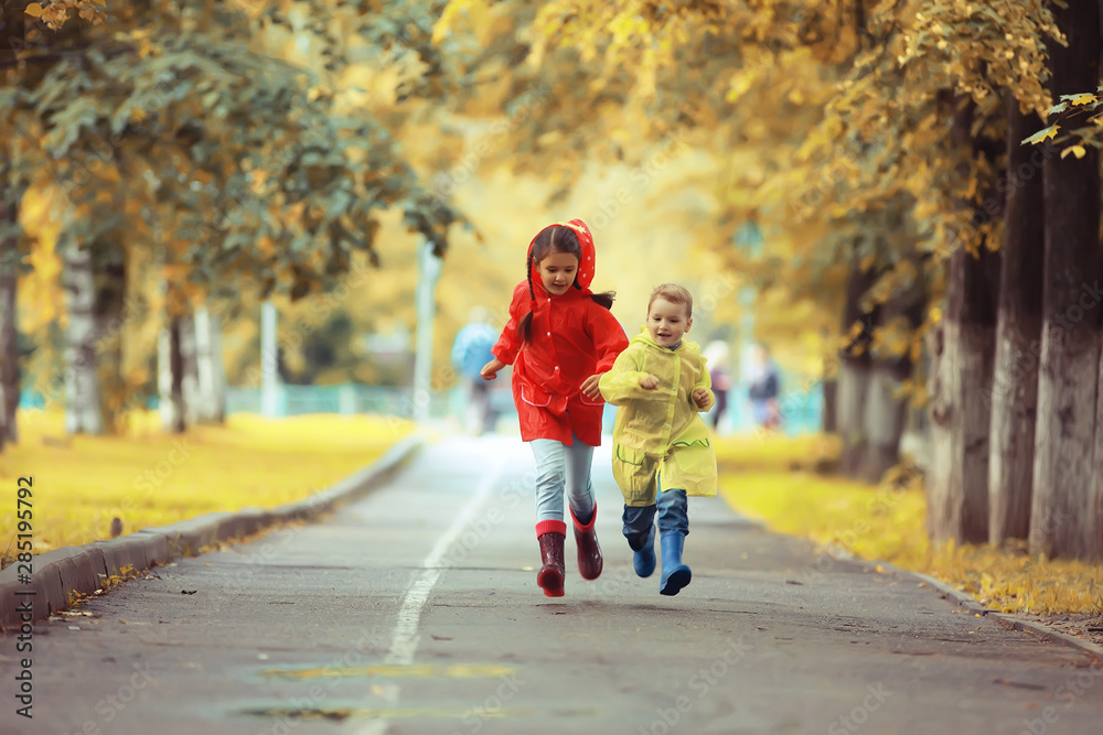 children run in the yellow autumn park rain / fun walk autumn seasonal landscape weather wet children run in the yellow autumn park rain / fun walk autumn seasonal landscape weather wet