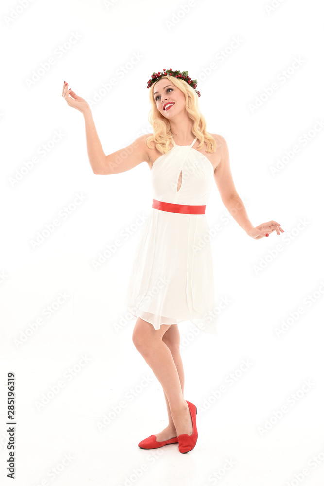 Fototapeta premium full length portrait of blonde girl wearing a white dress and flower crown. Standing pose, isolated against a white studio background.