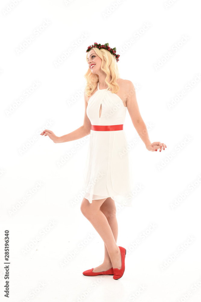 full length portrait of blonde girl wearing a white dress and flower crown. Standing pose, isolated against a white studio background. full length portrait of blonde girl wearing a white dress and flower crown. Standing pose, isolated against a white studio background.