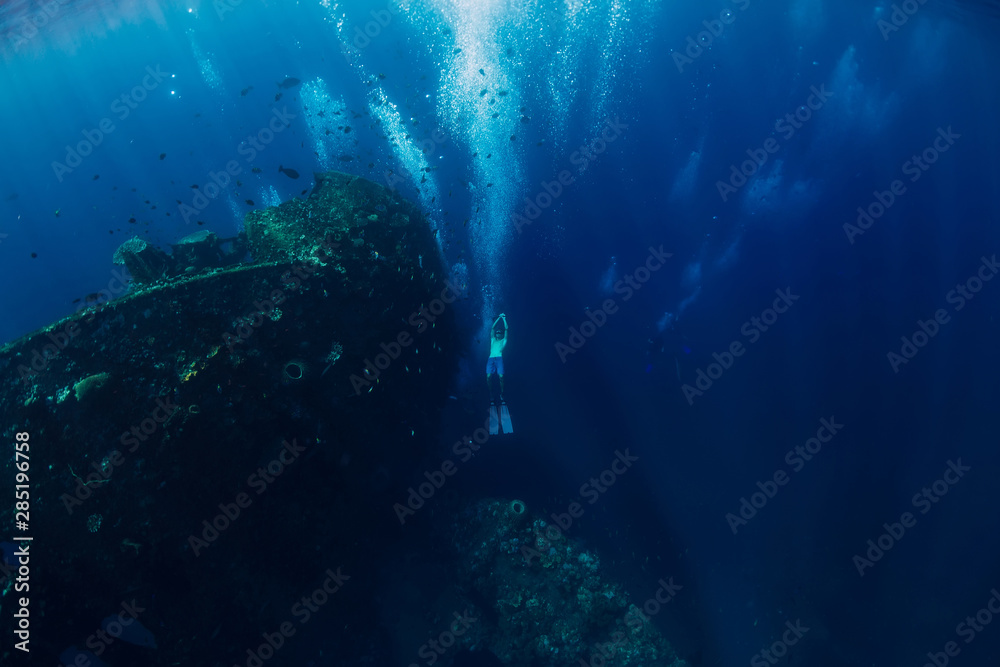 Freediver man dive underwater at shipwreck. Freediving in ocean