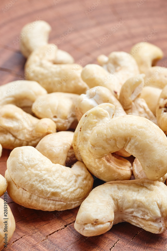 Close up picture of cashews on a wooden table, selective focus. Close up picture of cashews on a wooden table, selective focus.