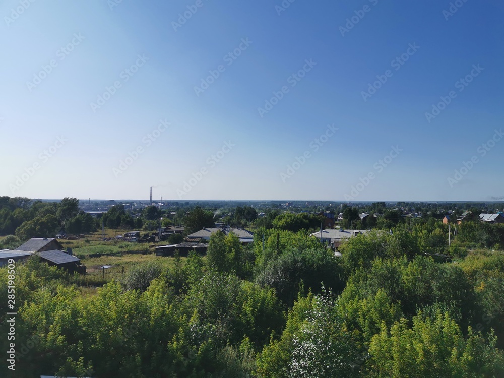 View of the Russian small town. Daytime photo, Anzhero-Sudzhensk, summer, the photo shows small houses and a lot of green vegetation. Landscape photo, sky.