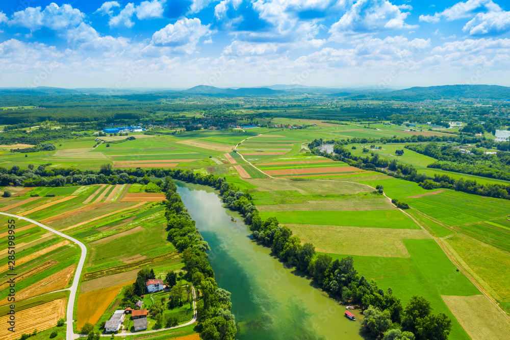 Rural countryside landscape in Croatia, confluence of Korana and Kupa rivers between agriculture fields and villages, panoramic view from drone 
