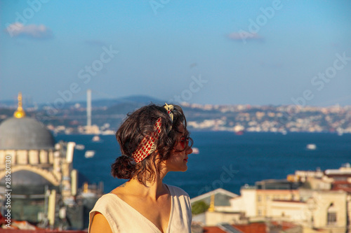 Eurasian woman standing at the roof with bosphorus background in Istanbul, Turkey