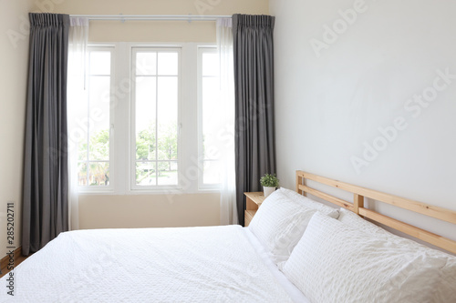 side view of new modern white wooden bed in white bedroom with soft and clear light