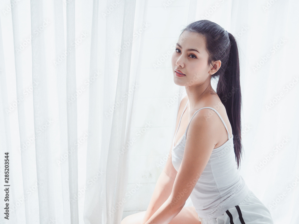 asian Beautiful woman sitting posing on a white bed asian Beautiful woman sitting posing on a white bed
