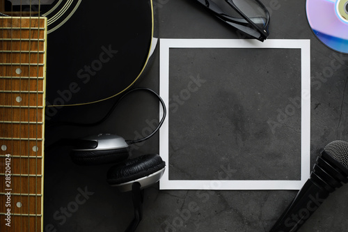 Guitar and accessories on a stone background. Desk musician, headphones, microphone. photo