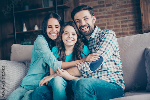 Portrait of cheerful people with brunet hair cuddling sit divan wear checkered plaid shirt denim jeans indoors