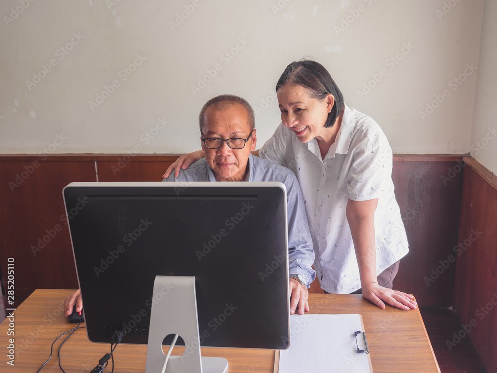 elder couple using computer together at home elder couple using computer together at home