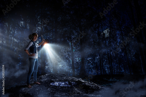 Young woman holding a flashlight © Sergey Nivens