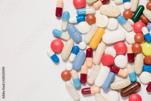 Pile of medical tablets and capsules isolated on white background. Closeup. 