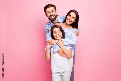 Portrait of cheerful family cuddling smiling wearing checkered plaid shirt off-shoulders white t-shirt isolated over pink background
