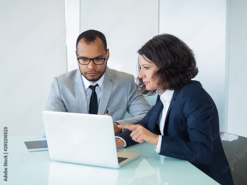 Female mentor showing presentation on laptop to intern. Business man and woman sitting at computer and looking at screen, woman speaking. Mentoring concept Female mentor showing presentation on laptop to intern. Business man and woman sitting at computer and looking at screen, woman speaking. Mentoring concept