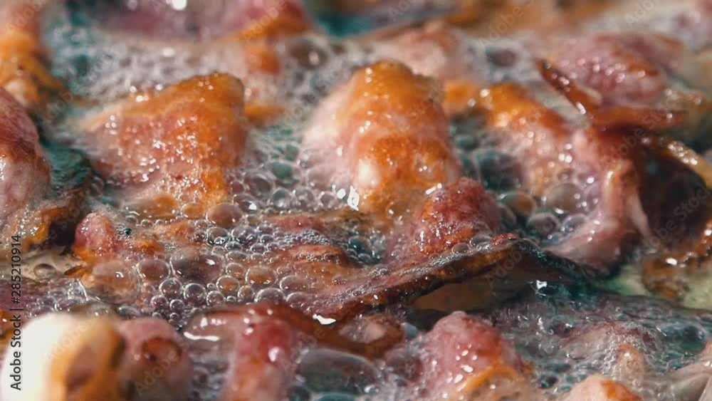 Close Shot of Delicious Crispy Rashers of Bacon Frying in a Pan with Bubbling Hot Oil Close Shot of Delicious Crispy Rashers of Bacon Frying in a Pan with Bubbling Hot Oil
