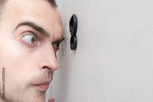 Foto Man look out through the peephole of front door, portrait, closeup, toned