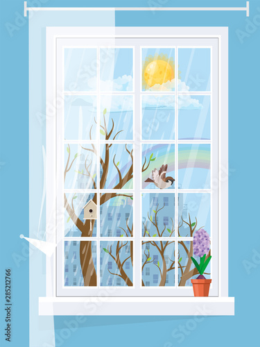 A cozy window with a spring landscape with hyacinth on the windowsill.