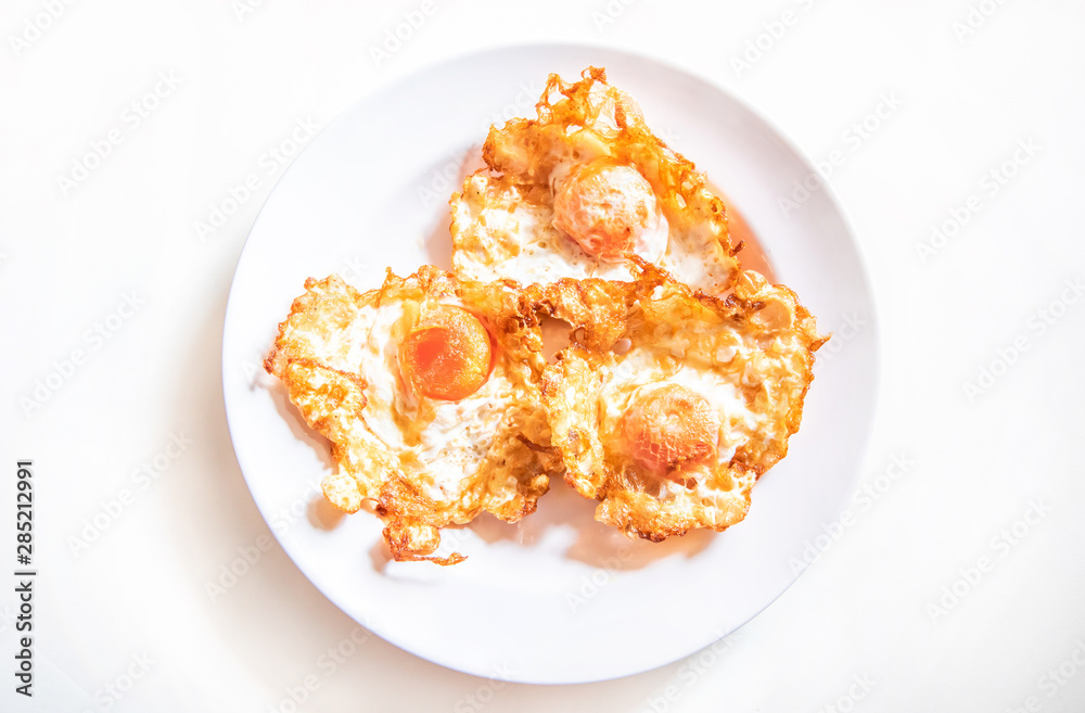 A fried egg (salted egg) for breakfast on white plate background.