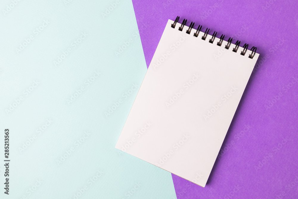 Notebook on a black spiral with white sheets on a colorful background. The concept of education, writing down ideas, plans. Place for text. Minimalism, flat lay. Notebook on a black spiral with white sheets on a colorful background. The concept of education, writing down ideas, plans. Place for text. Minimalism, flat lay.