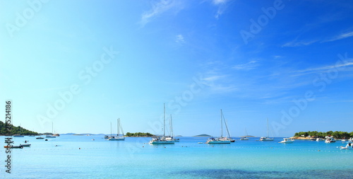 Beautiful blue sea in Camp Kosirina on Island Murter in Croatia, sailing ships in background photo